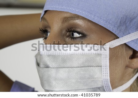 Surgical nurse putting on her mask