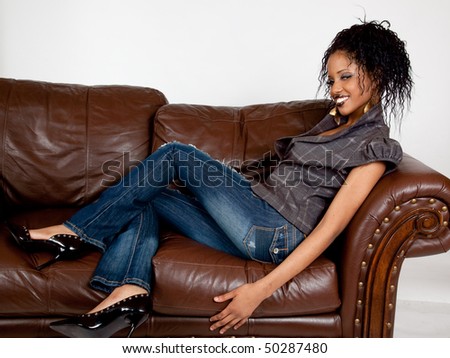 Lovely African American woman happy and reclining on a couch