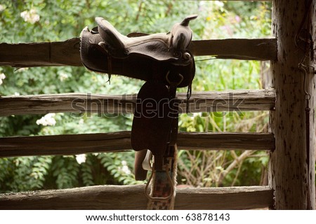 Western saddle on a fence