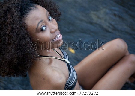 Lovely black woman outside, in a swimsuit and looking up