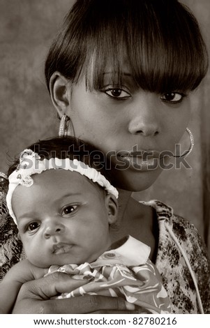 Pretty black mother holding her young daughter over her shoulder
