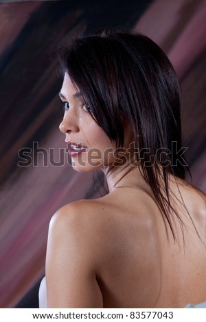 Serious woman looking to the left over her shoulder, from the back
