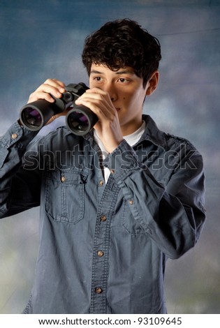 Young man with a pair of binoculars, watching and observing