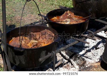 Food cooked over an open fire in cast iron pots and pans