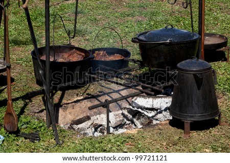 Food cooked over an open fire in cast iron pots and pans