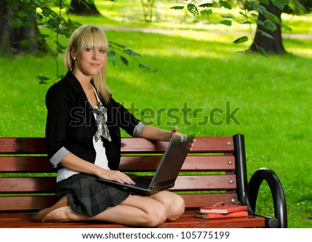 Girl using a laptop studying for the exam in the park