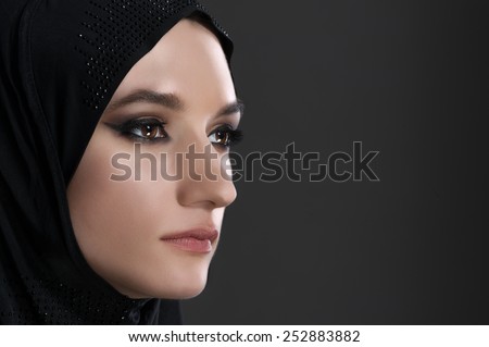 pretty young muslim woman head shot over gray background studio shot pretty young muslim woman head shot over gray background studio shot