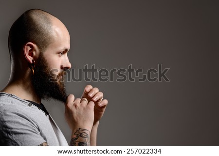 Side view portrait of  bearded man touching his beard