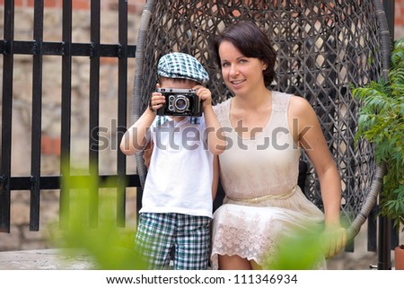 Mother and her little son with retro camera