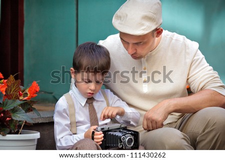 Father and little son with retro camera outdoors