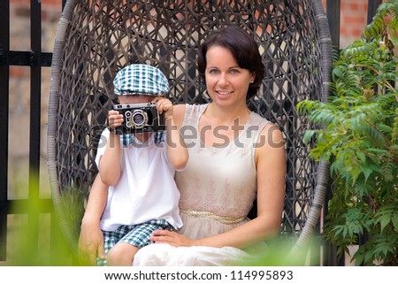 Mother and her little son with retro camera