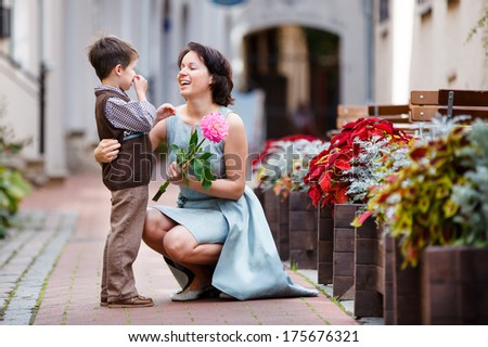 Little boy giving flower to his mom