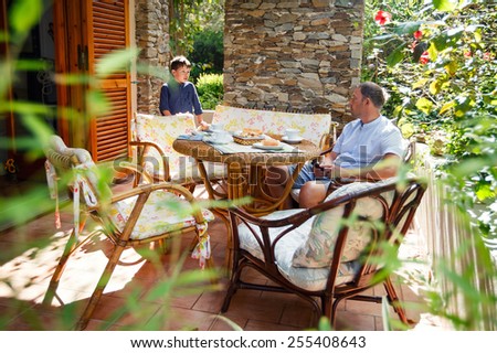 Father and son together on patio on beautiful summer day
