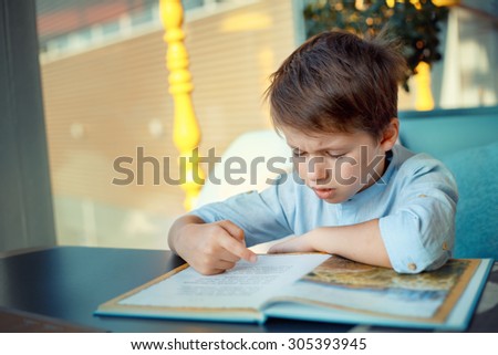 Boring and tired little boy reading book for elementary school