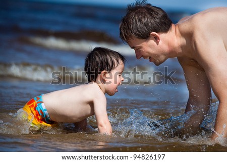 Happy father and his 2 years old boy enjoying a summer day at the seaside