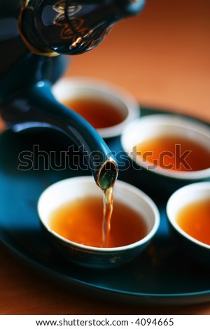 Pouring fresh tea to elegant china teacups.
