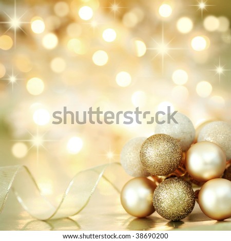 Gold Christmas baubles and ribbon on background of defocused golden lights. Shallow DOF.