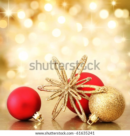 Red and gold Christmas baubles and star on background of defocused golden lights. Shallow DOF.