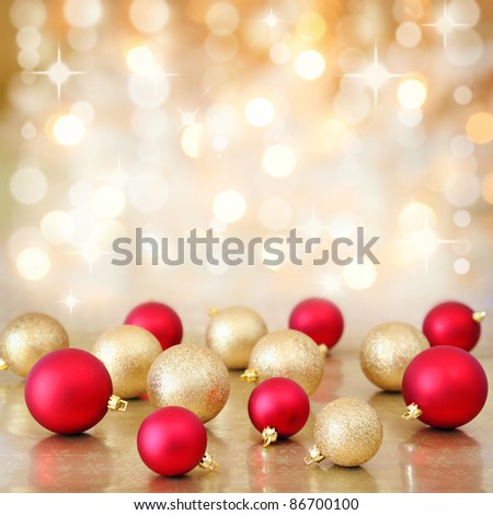 Red and gold Christmas baubles ornaments on background of defocused golden lights. Shallow DOF.