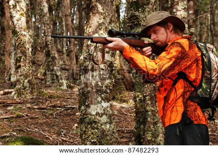 hunter in forest wearing blaze orange safety clothing