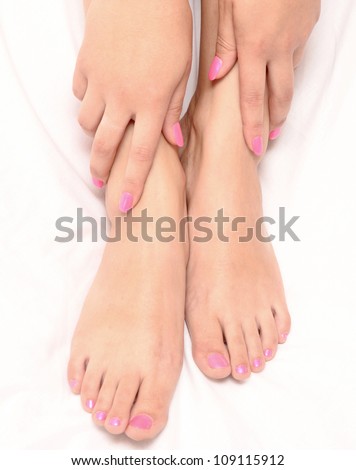 woman hands and feet with manicure and pedicure on white