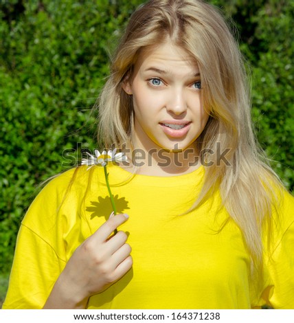 portrait of young wonder woman with camomile flower