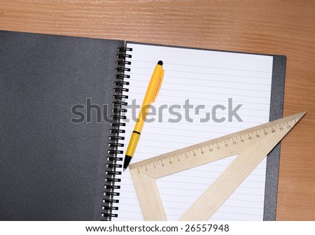 Notebook, pencil, ruler on a wooden background
