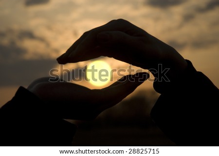 two hands holding the sun