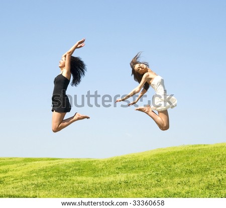 two happy jumping woman on a sky background
