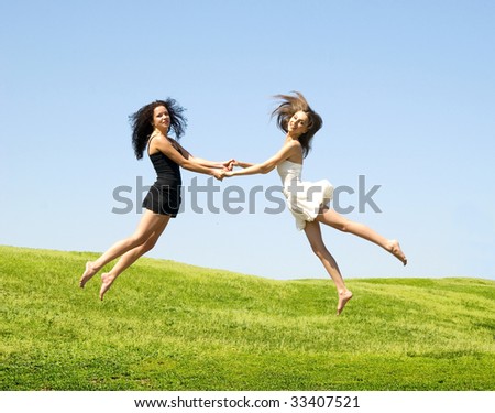two happy jumping woman against nature background