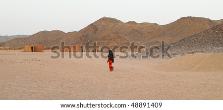 walking bedouin woman in desert