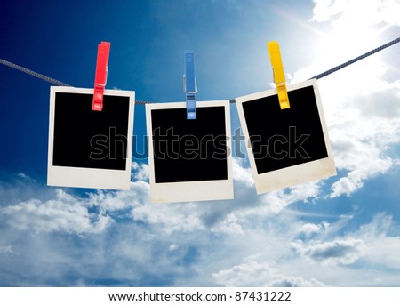 photo frames on a rope against sky background