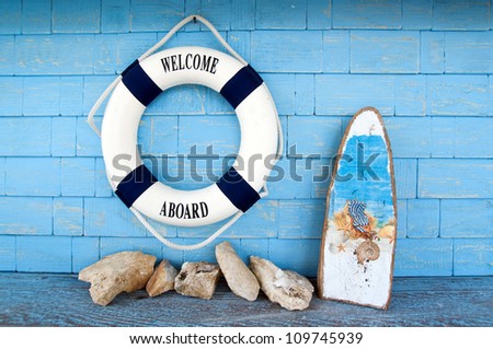 Life buoy with welcome on board on it hanging on blue wall