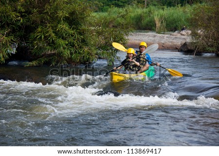 Young couple enjoy white water kayaking in Mae Rawa  river , North of Thailand