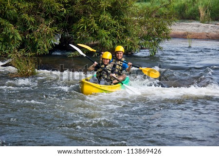 Young couple enjoy white water kayaking in Mae Rawa  river , North of Thailand