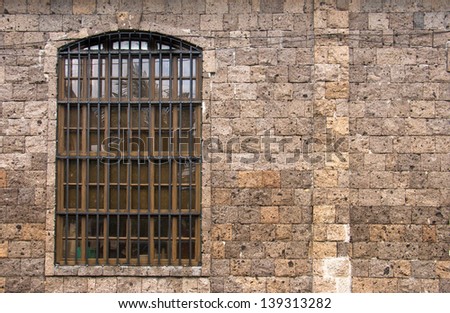 curved steel window on brown masonry rock wall