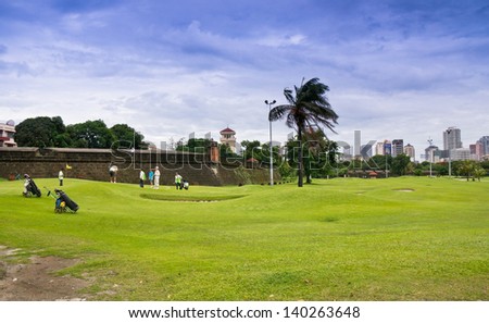 MANILA, PHILIPPINES - MAY 2 : A Group of golfers at Club Intramuros Golf Course on May 2,2012 in Intramuros district of Manila , Philippines.The golf course surrounds Intramuros\'s ancient wall.