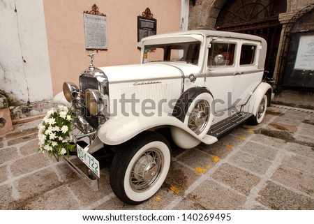 MANILA, PHILIPPINES -MAY 6:A classic wedding car park in front of  San Agustine church during a wedding ceremony on May 6,2012  Intramuros district of Manila, Philippines.