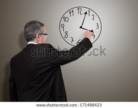businessman adjusts his imaginary clock on abstract background