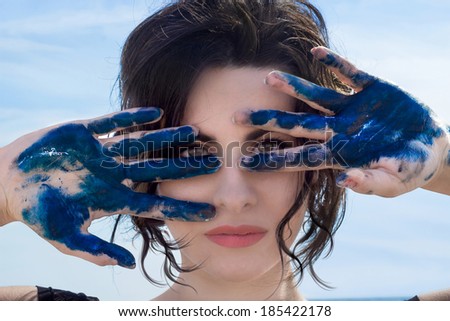 beautiful woman showing her hands blu paint