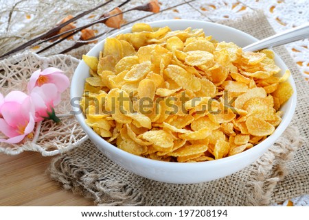 breakfast table with cornflakes cereal and pink flowers