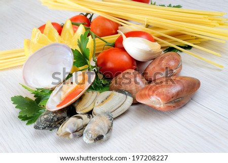 raw sea fruits called fasolari live again with lemon and spaghetti pasta ingredients