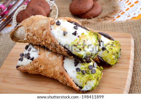 very sweet cannoli siciliani filled by ricotta cheese and sugar whit pistachios and chocolate drops