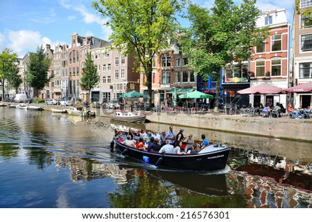 AMSTERDAM, AUGUST 4: Tourists on the boat visiting Amsterdam and is visited every year by about 4 million tourists.The best way is to visit them on board of the boat on August 4, 2014 in Amsterdam
