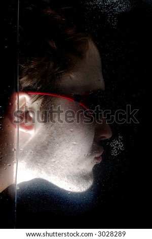Photo of male face in the water on a black background.