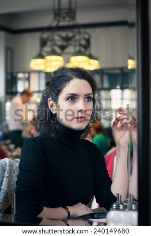 Young woman smoking in a stylish old European cafe