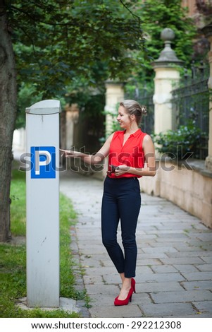 Beautiful young woman paying for parking