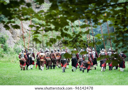 Historical scene: soldiers in ancient costumes and armors marching into the battle