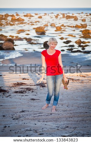 Girl walking along the beach and smiling at the camera