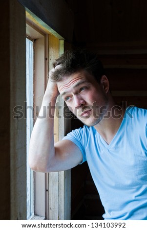 Young man tired and looking at the window